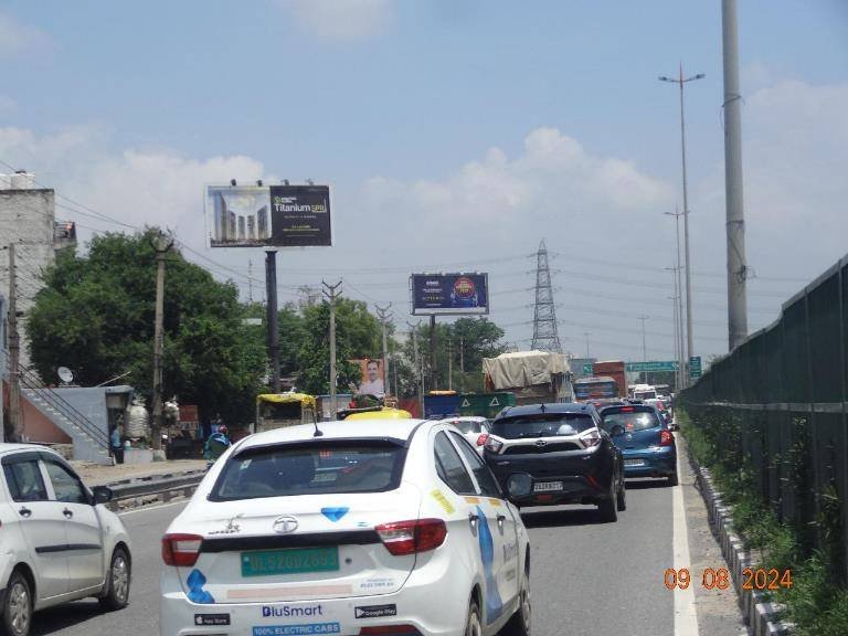 Highway hoarding advertising in Gurugram showcasing brand visibility along a busy highway, managed by leading advertising companies for maximum exposure.