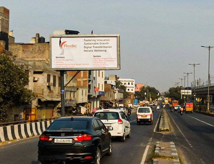 Large outdoor Unipole by Acme Advertiser displayed on a busy roadside, showcasing high-impact hoarding advertising for brand visibility in urban India.Top Digital Billboard Advertising Companies in Delhi