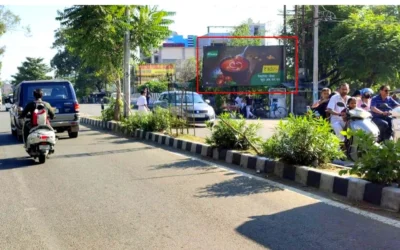 Street scene with festive cartoon hoarding, CHAWLA shop, and ACME Advertising Co.'s outdoor branding in Jammu and Kashmir.